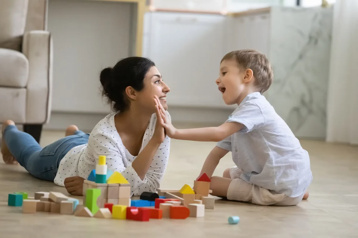 une jeune femme tapant dans la main d'un petit garçon