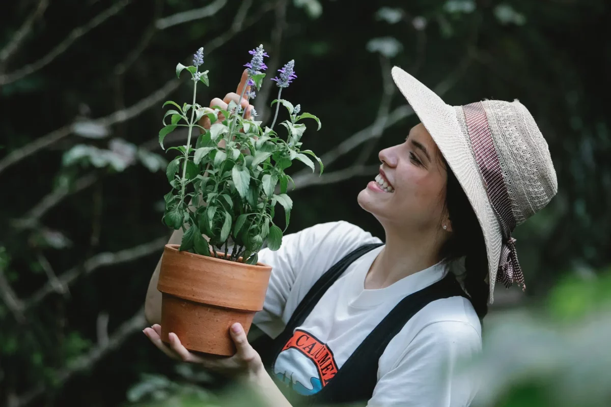 Une jeune femme entrain de tenir un pot contenant une plante