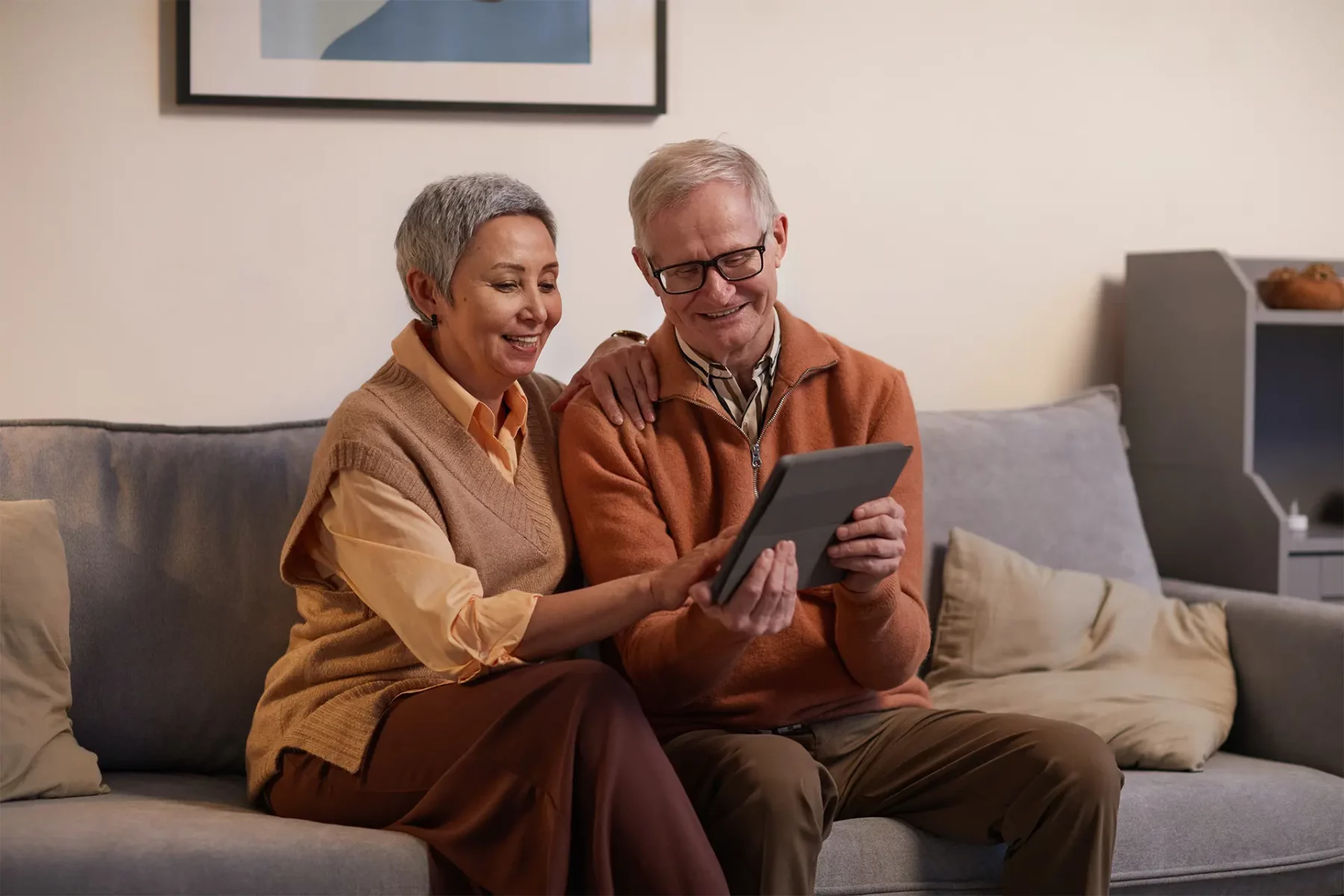 Un couple de personnes âgées devant une tablette