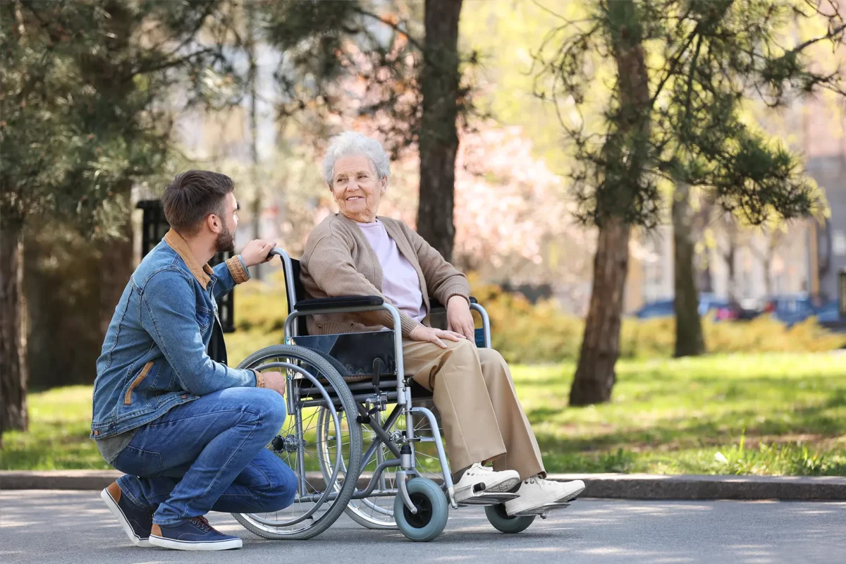 Un auxiliaire de vie discutant avec une femme en fauteuil roulant