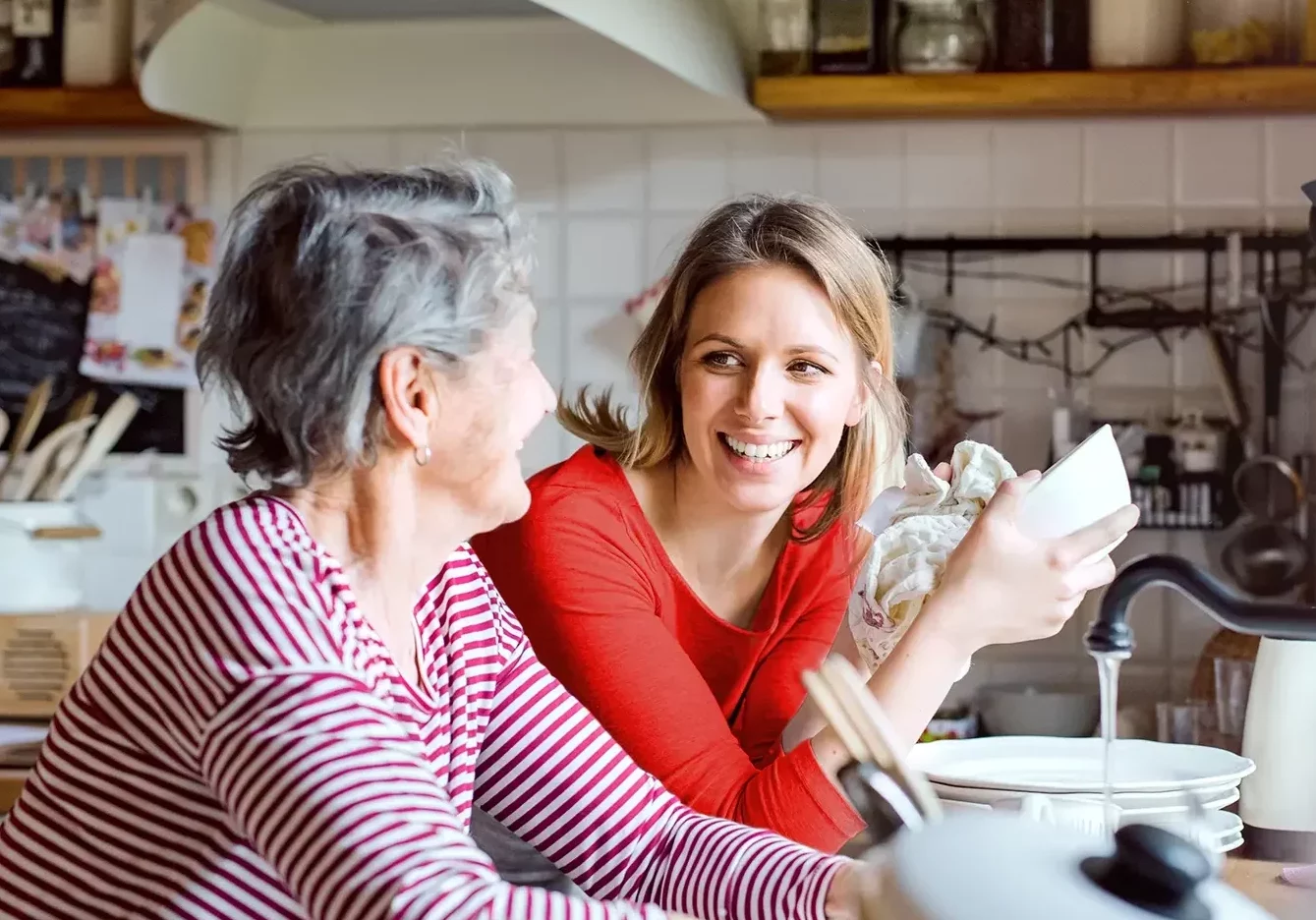 Une jeune femme faisant la vaisselle avec une femme plus âgée