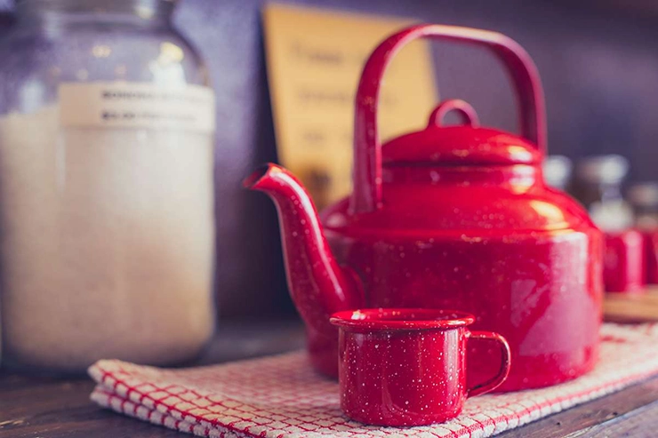 une bouilloire avec une petite tasse à côté