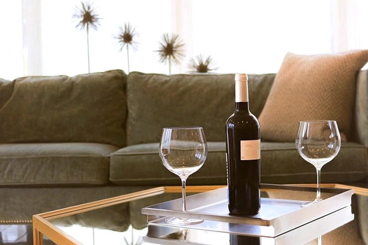 une verre et une bouteille posés sur une table devant un canapé