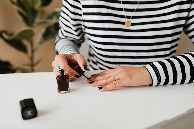 Une femme se mettant su vernis sur les ongles