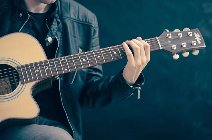 Un homme qui tient une guitare dans ses mains