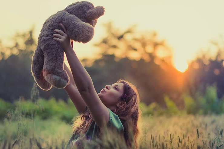 une petite fille tenant une peluche dans ses bras