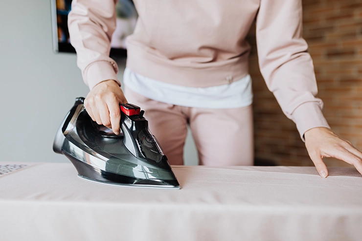 Homme qui repasse une chemise sur une table à repasser