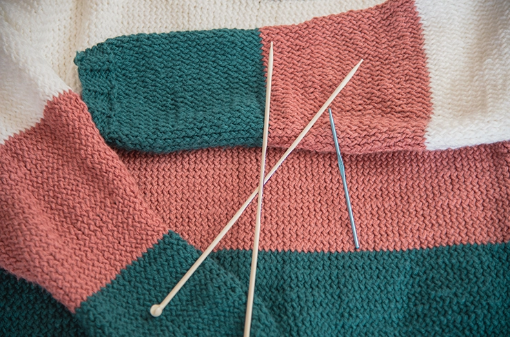 Pull en laine avec des aiguilles à tricoter sur le dessus