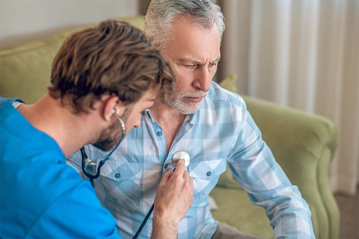 Photo d'un médecin qui ausculte un homme avec un stéthoscope