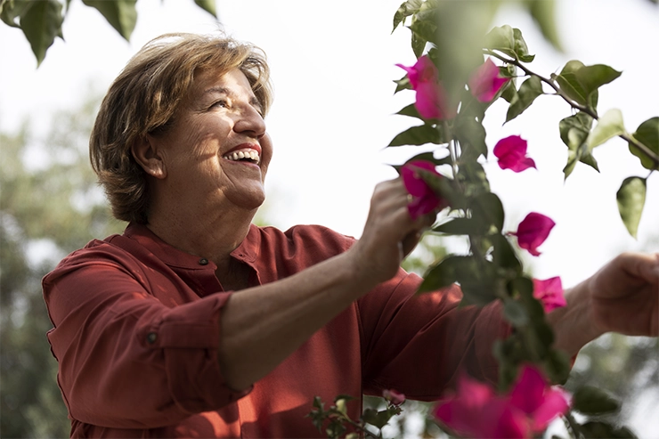 Une femme souriante en train de jardiner