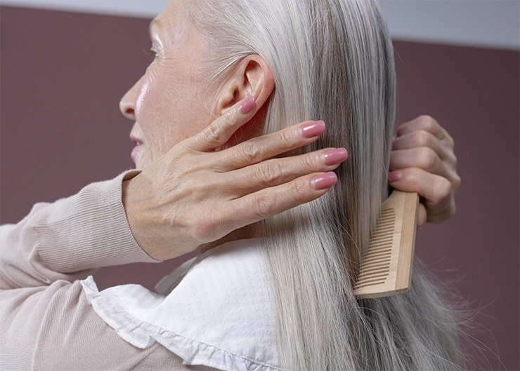 Femme âgée qui se peigne les cheveux